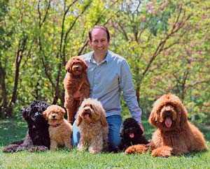 home amb gossos i cadells en un parc a la natura