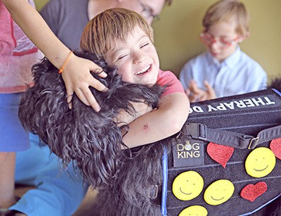 niño abrazando a perro de terapia