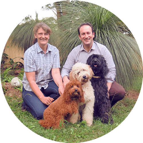 man and woman with dogs in garden round image