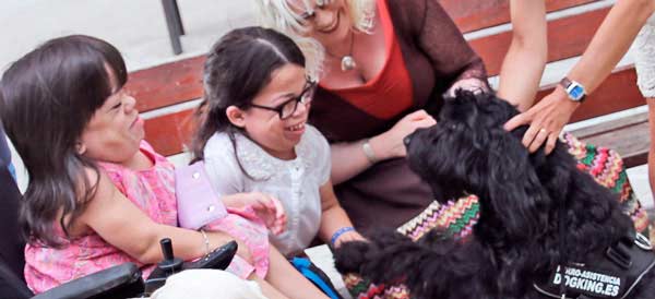 dog giving paw to girls with special needs