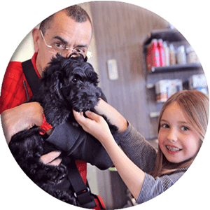 fille et homme avec chiot noir, image ronde