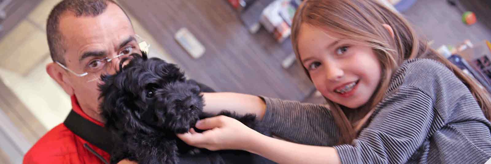 girl and man with black puppy